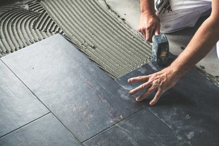 A family removing muddy shoes on a tiled entryway floor inside a bright, lived-in home.